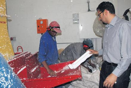 Noel Ehrenreich demonstrates how polystyrene is fed into the machine.